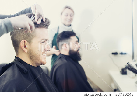 Clients having their hair cut by hairdressers Clients having their hair cut by hairdressers 33759243