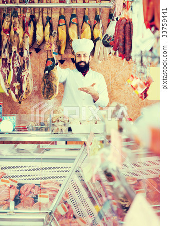 Ordinary man seller showing jamon 33759441