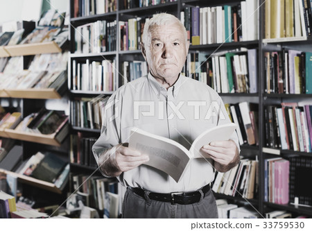 Old male is choosing book for reading in free time in bookstore. Old male is choosing book for reading in free time in bookstore. 33759530