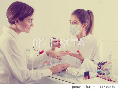 Woman doing shellac manicure 33759819
