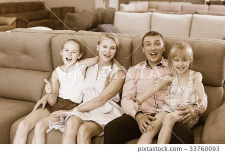 Family is pleased by new sofa in store. Family is pleased by new sofa in store. 33760093