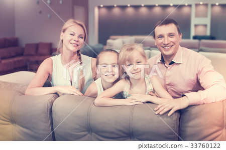 Family posing near new sofa 33760122