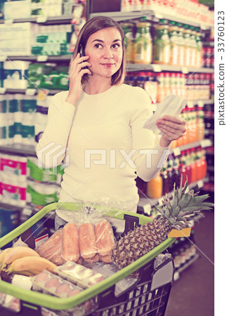 Happy female talking on phone about shopping 33760123