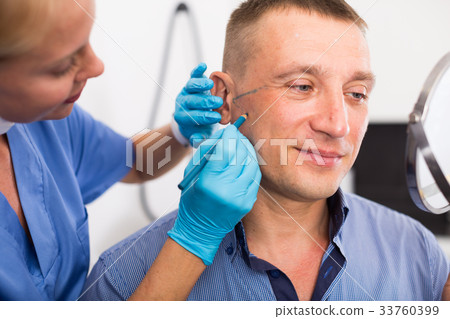 Female doctor is preparing patient for procedure with using marker Female doctor is preparing patient for procedure with using marker 33760399