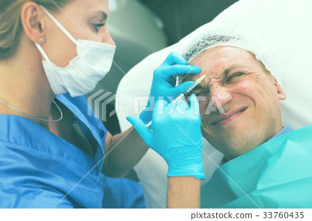 Female specialist is doing injection to client for anti-aging Female specialist is doing injection to client for anti-aging 33760435
