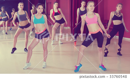 Cheerful active women exercising dance moves Cheerful active women exercising dance moves 33760548