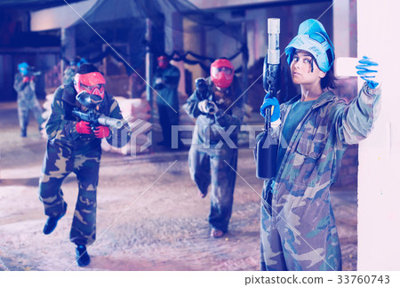 woman in blue mask is making selfie on battlefield of paintball club. woman in blue mask is making selfie on battlefield of paintball club. 33760743