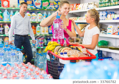 Smiling young woman and man with child choosing water 33760782