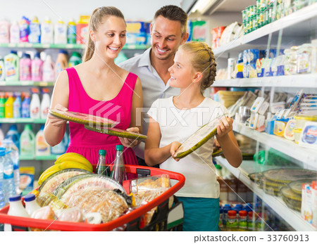 Happy young wife and husband with kid choosing margarita pizza Happy young wife and husband with kid choosing margarita pizza 33760913