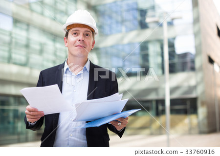 Man in helmet working with documents Man in helmet working with documents 33760916