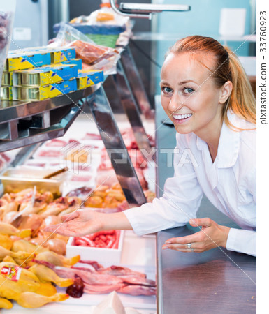 Woman working in supermarket in delicatessen section Woman working in supermarket in delicatessen section 33760923
