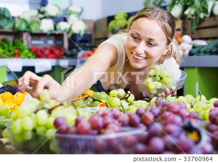 Woman customer buying sweet ripe grapes on marketplace 33760964