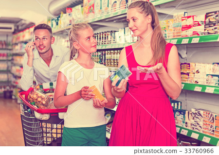 Cheerful woman and teenager girl in the grocery shop. male on backdrop Cheerful woman and teenager girl in the grocery shop. male on backdrop 33760966