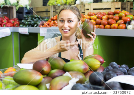 young woman selling mango at market . 33760972