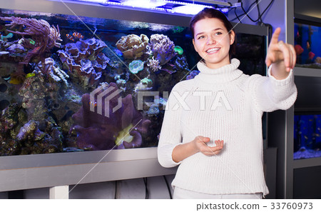 Girl pointing to other model of aquariums Girl pointing to other model of aquariums 33760973