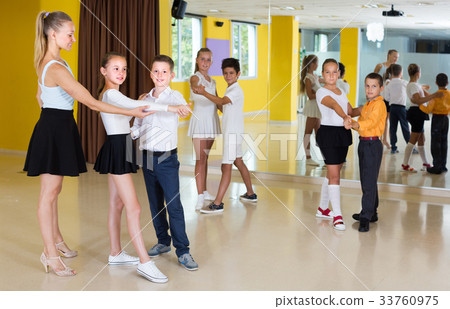 Teacher is demonstrating to children how to dance waltz Teacher is demonstrating to children how to dance waltz 33760975