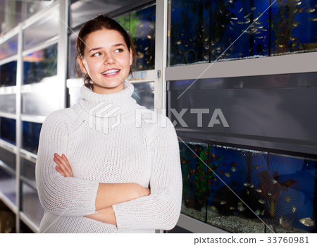 Woman watches bright aquarium fish Woman watches bright aquarium fish 33760981