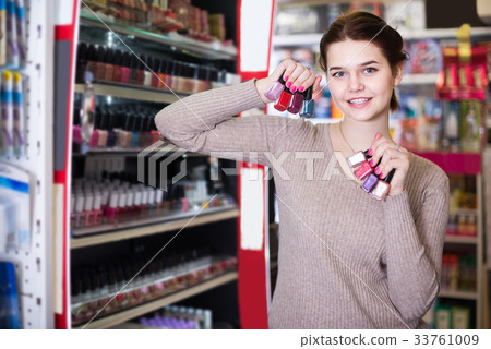 female customer looking for nail polish in cosmetics shop female customer looking for nail polish in cosmetics shop 33761009