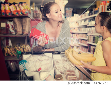 Smiling mom with girl is choosing fresh goods 33761238