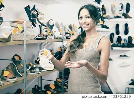 Female customer showing desired shoe in boutique 33761239
