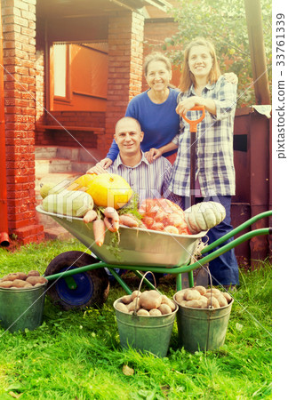 Man and two women with vegetables in garden Man and two women with vegetables in garden 33761339