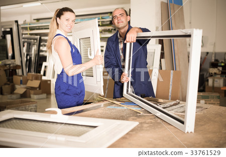 Portrait of smiling two workers assembling pvc windows Portrait of smiling two workers assembling pvc windows 33761529