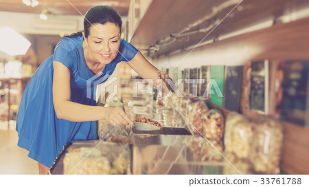 Girl is taking nut beans by weight Girl is taking nut beans by weight 33761788