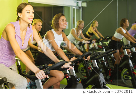 women on cardio training on exercycles in health club women on cardio training on exercycles in health club 33762011