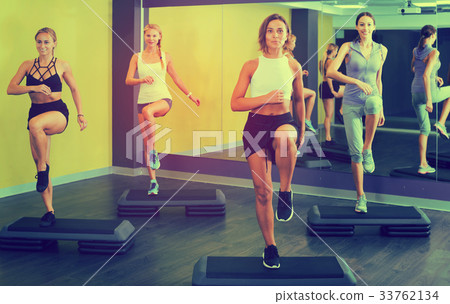 Women doing step aerobics exercises 33762134