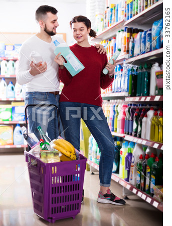 two adult people in good spirits selecting detergents in the store two adult people in good spirits selecting detergents in the store 33762165