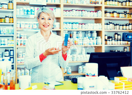 Mature female seller suggesting useful skin care products Mature female seller suggesting useful skin care products 33762412