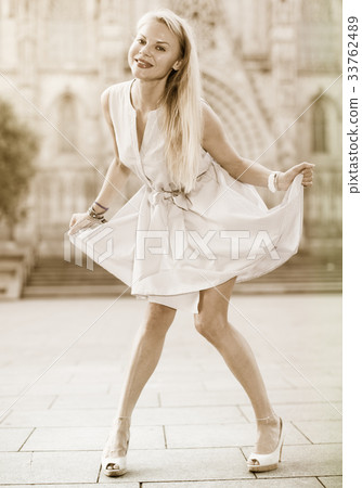 woman in the dress moving at the street 33762489