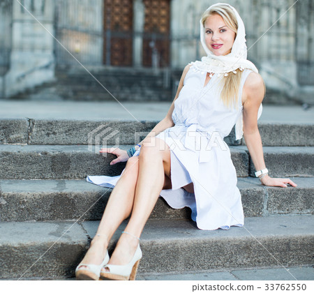smiling woman sitting in the city center in shawl 33762550