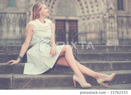 woman in shawl sitting on stone steps 33762555