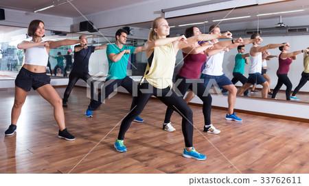 Young positive people learning zumba steps 33762611