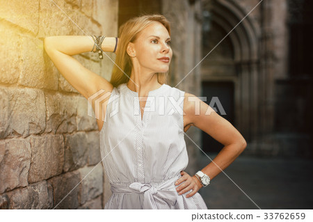 smiling woman near the stone wall 33762659