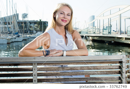 female sitting at bench near the marina bay female sitting at bench near the marina bay 33762749