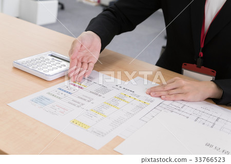 Female employee explaining financial plan of house at counter 33766523