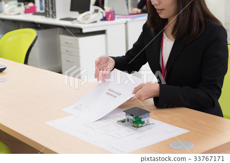 Female employee explaining existing housing survey report at counter Female employee explaining existing housing survey report at counter 33767171