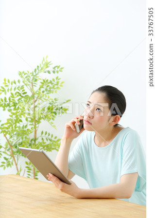 一個女人看著一台平板電腦 33767505