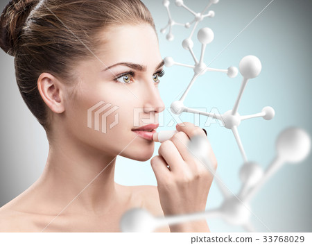 Woman putting lipbalm in big molecules chain. 33768029