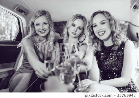 Pretty women having party in a limousine car and 33769945