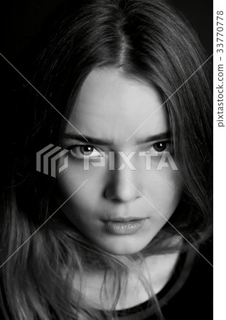 Young beautiful girl. Hard serious look at the 33770778