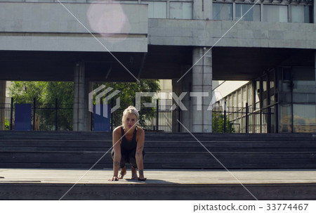 A young woman sitting on wooden flooring A young woman sitting on wooden flooring 33774467