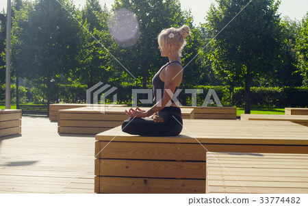 Young woman meditating in the park Young woman meditating in the park 33774482