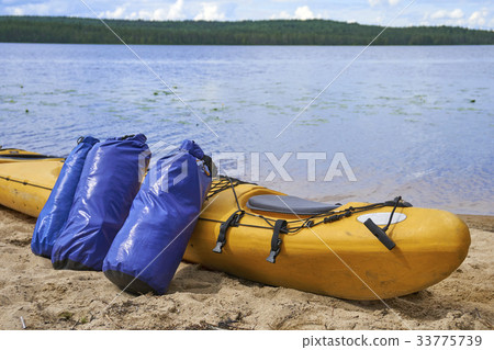 Waterproof bags standing by yellow plastic kayak 33775739