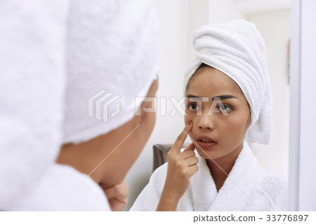 Asian woman with bath towels cleanses her face 33776897