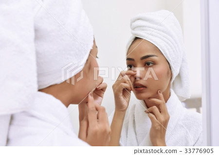 Asian woman with bath towels cleanses her face 33776905
