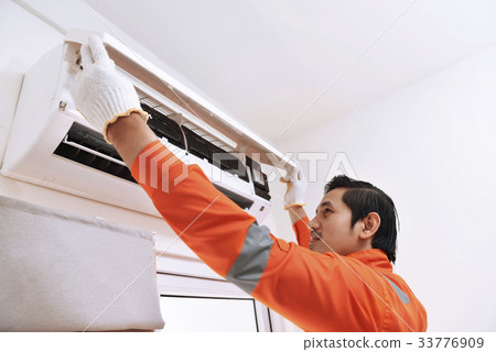 Asian male technician repairing air conditioner 33776909