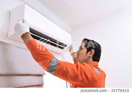 Asian male technician repairing air conditioner 33776919